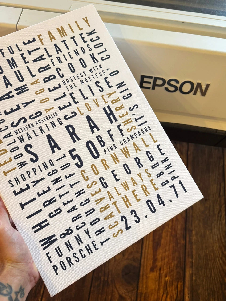 A personalised Sarah Word Art canvas held beside an Epson printer in the YI2C workshop.