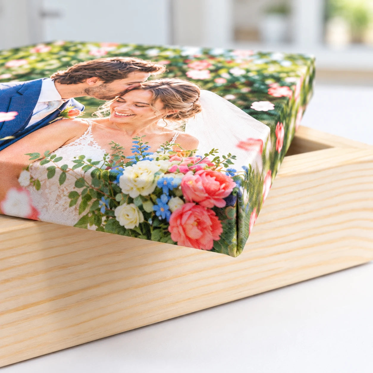 Close-up of a wedding photo canvas showing the wrapped corner and pale pine timber beneath.