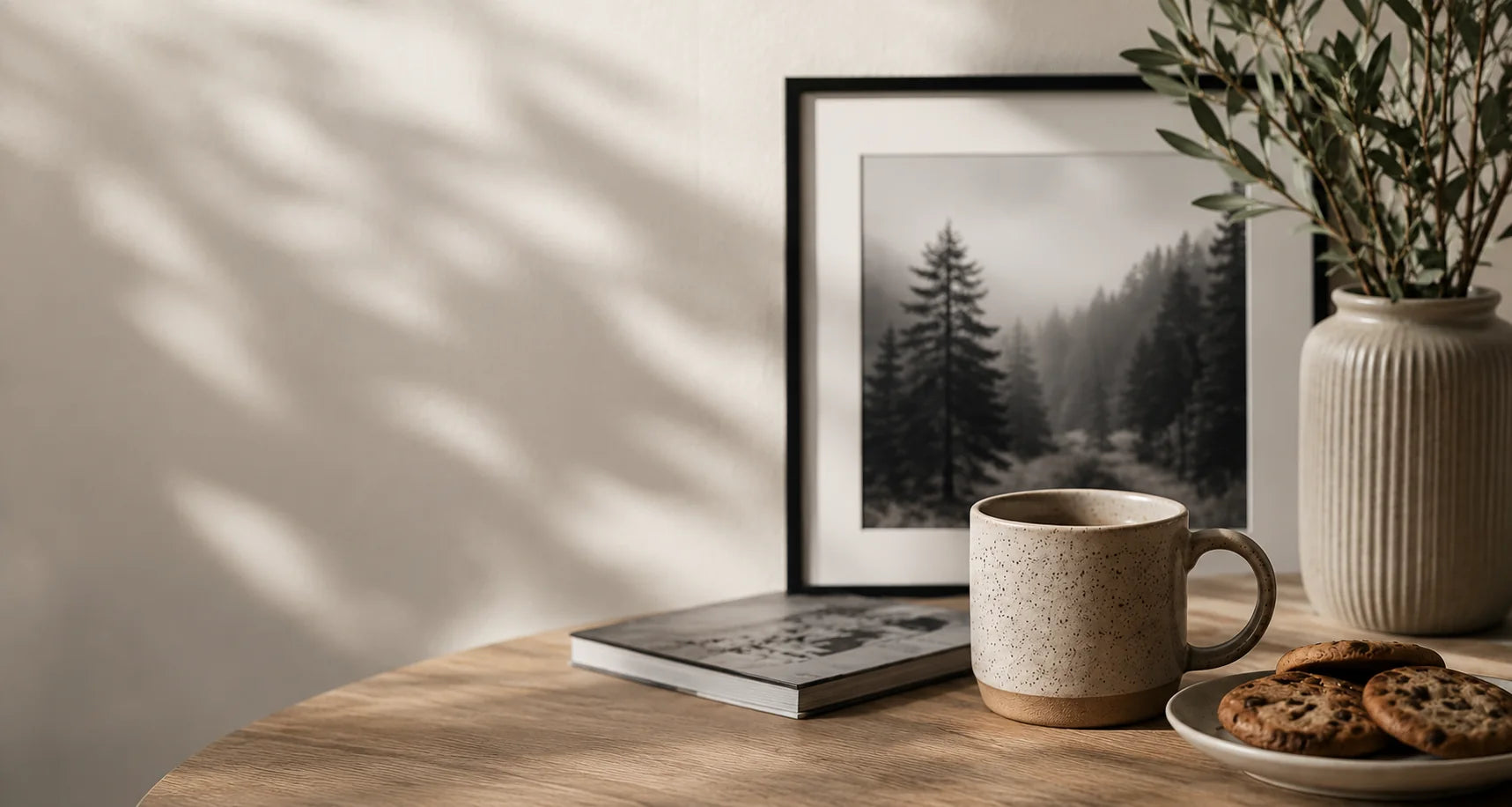 A mug of tea and cookies beside a framed photographic print