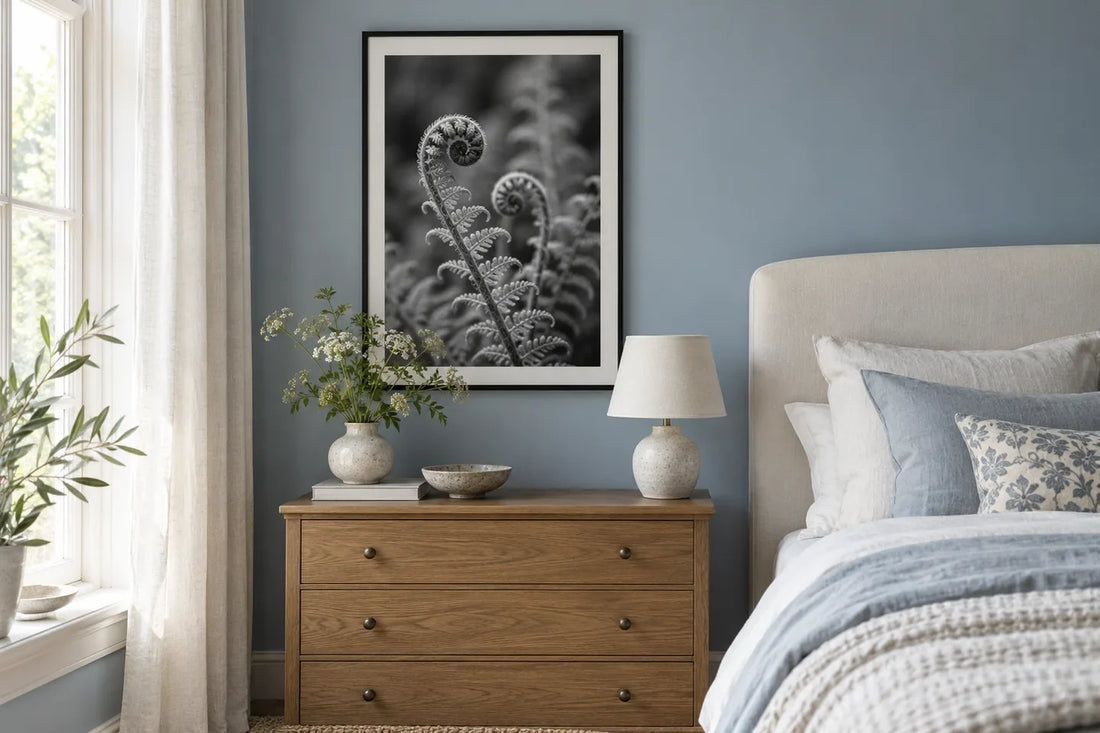A framed black-and-white botanical photograph displayed in a blue bedroom.