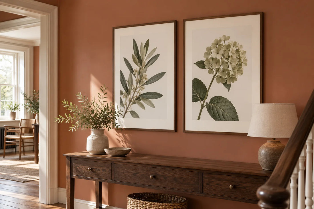 Two framed botanical posters with white surrounds displayed above a hallway console.
