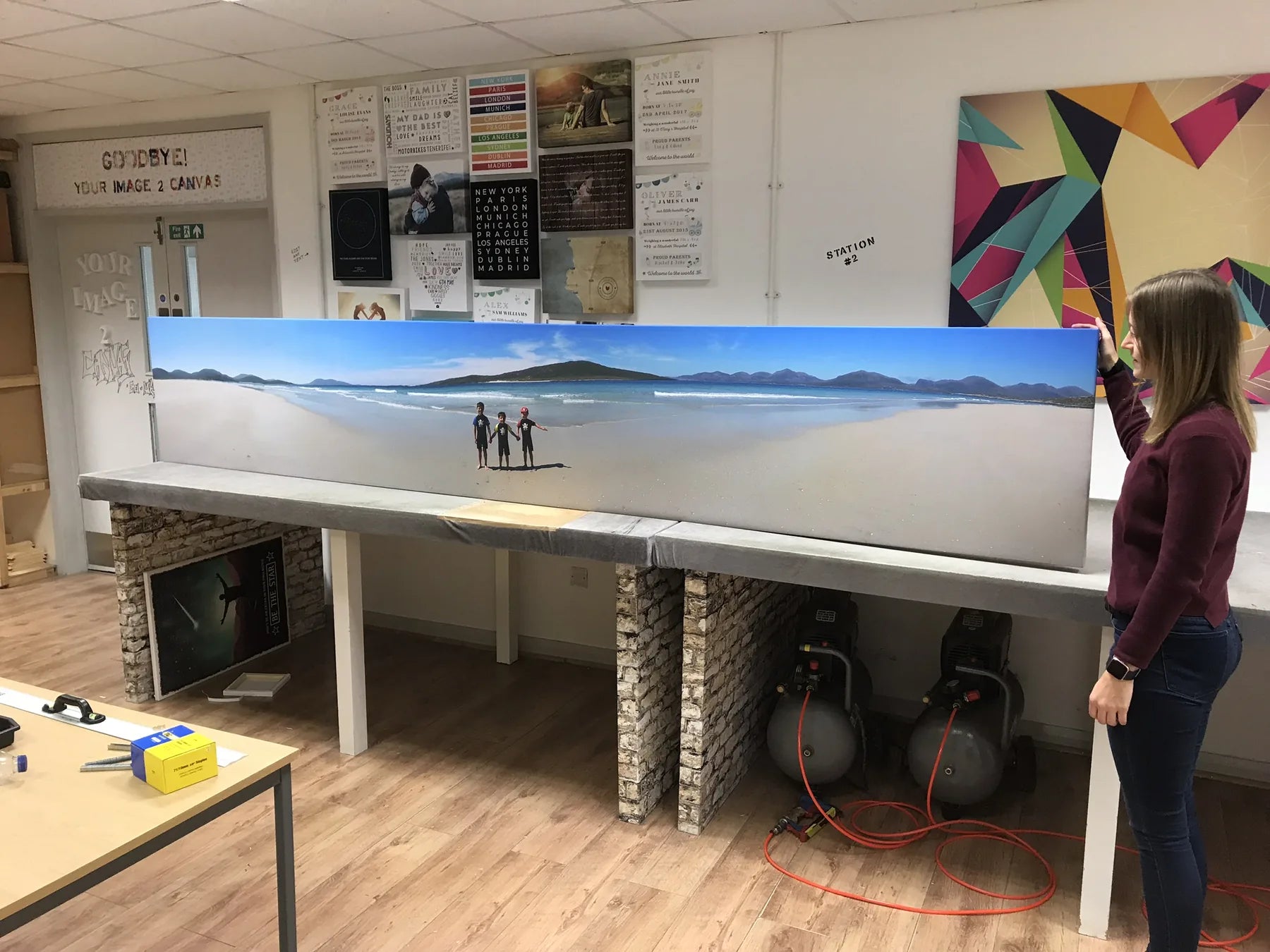A person standing beside an exceptionally wide panoramic canvas