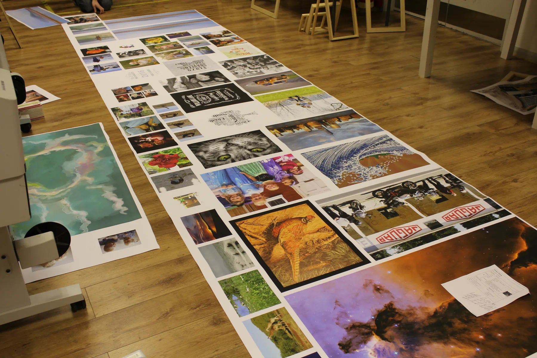 A long table covered with freshly printed artwork awaiting checks