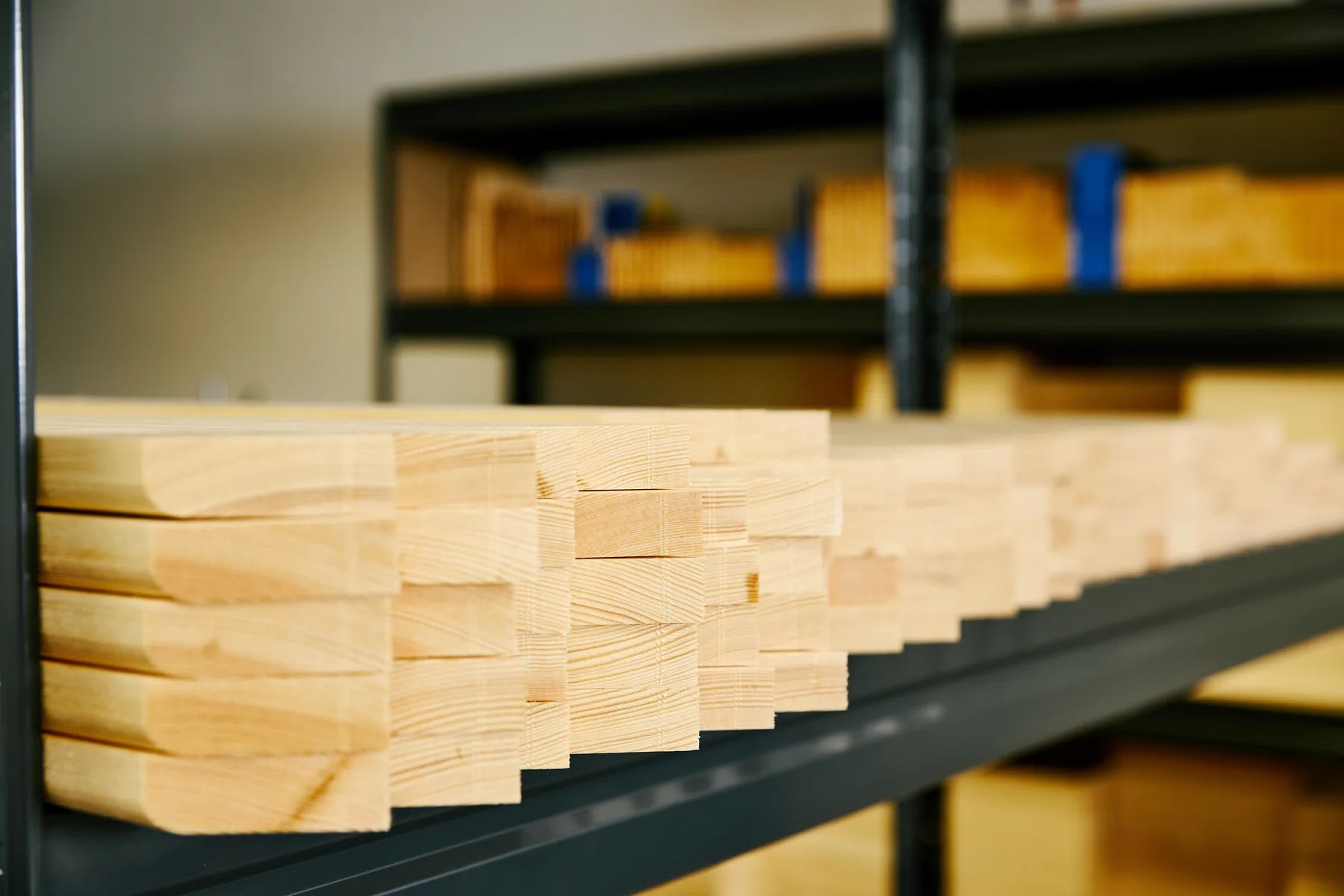 Solid pine stretcher bars stacked on workshop shelving