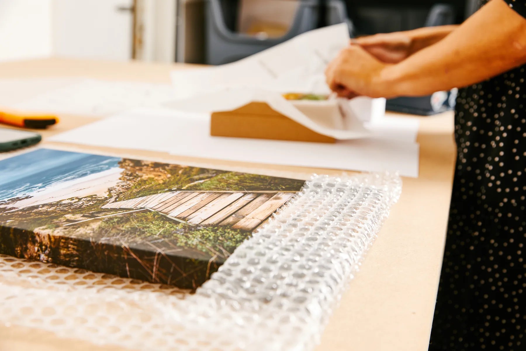 A finished photographic canvas being wrapped for dispatch