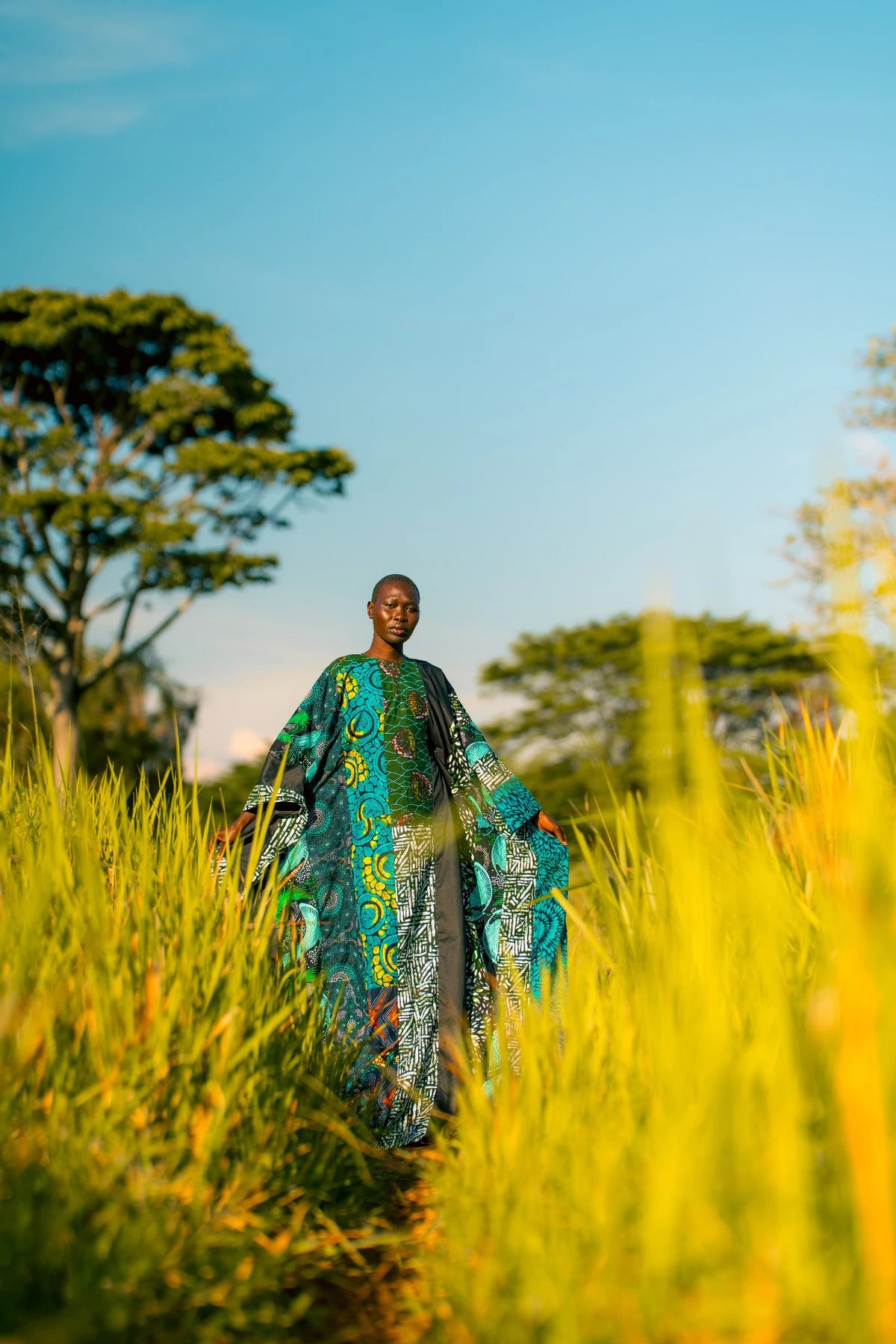 Full-length turquoise outfit photograph in tall grass with blue sky