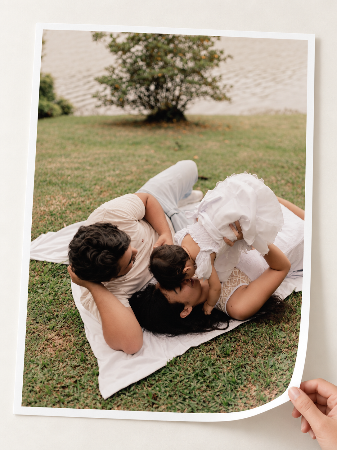 Single family photograph printed on paper, with a hand lifting the bottom corner
