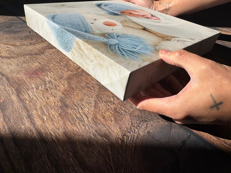 A baby photo canvas held at an angle to show its depth and wrapped edge