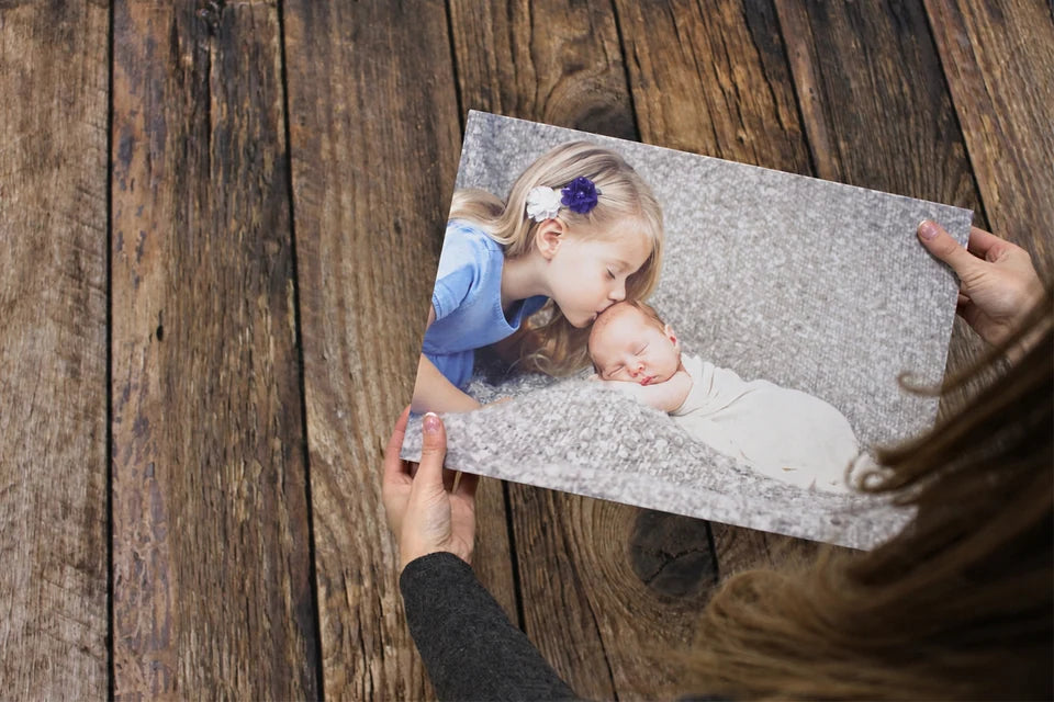 Hands holding a family photo canvas over the workshop worktop