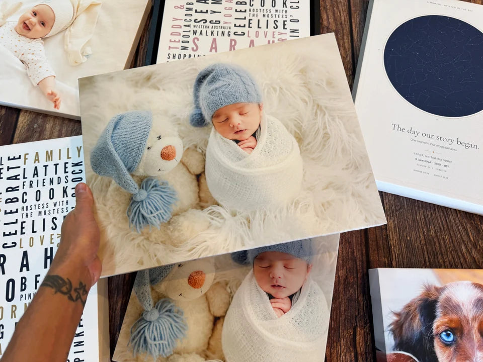 A baby photo canvas held among finished personalised prints