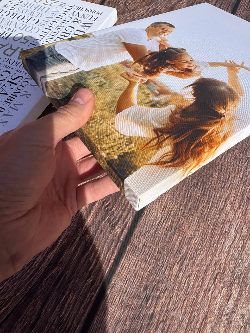 A photo canvas held in sunlight showing the surface and wrapped side