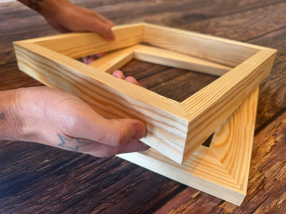 Hands holding a finished solid pine canvas frame