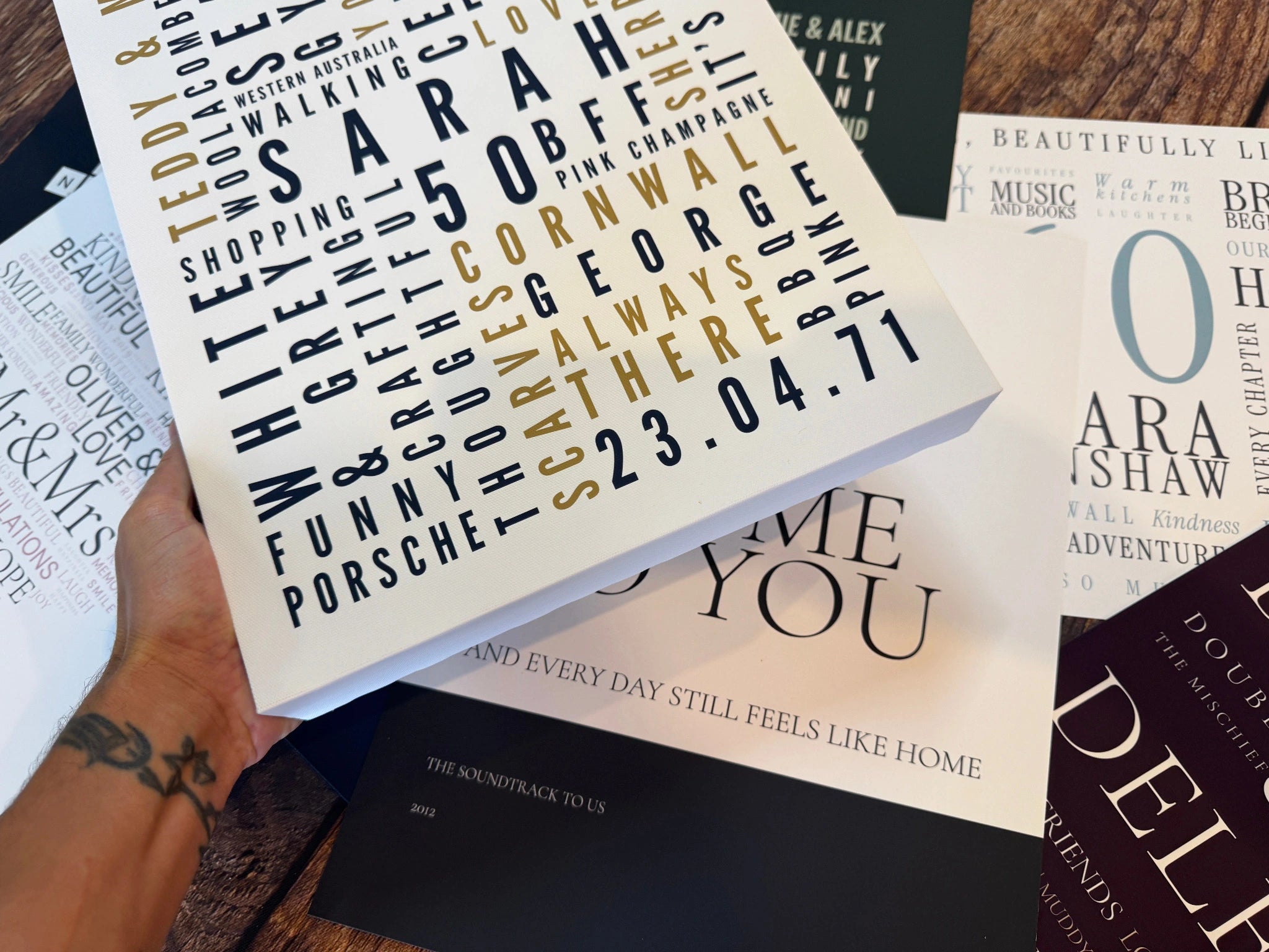 A hand supporting a chunky Word Art canvas, showing the printed face, wrapped side and corner.