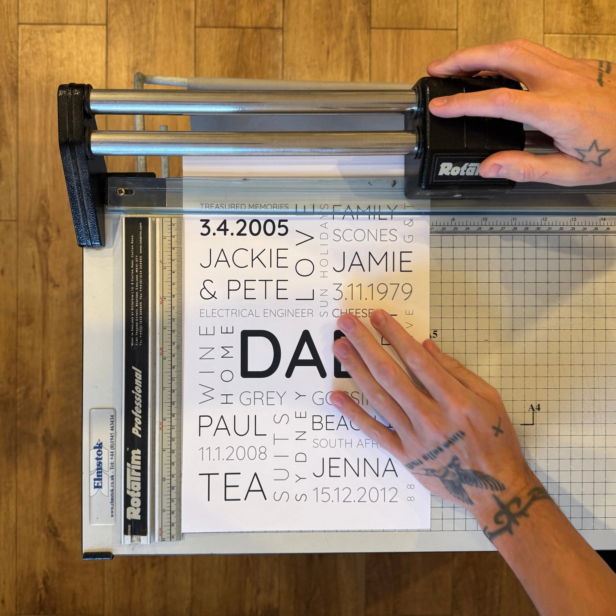 A personalised Dad Word Art poster being trimmed by hand in the workshop.