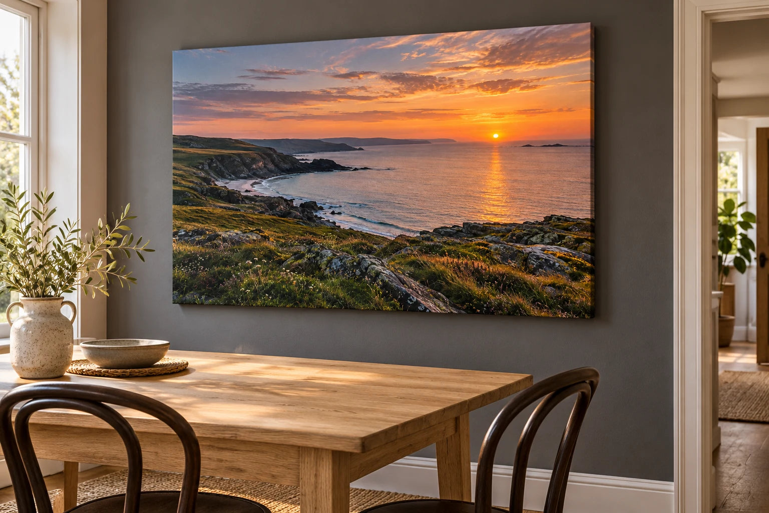 Illustrative dining space with the sunset coast photograph on a landscape stretched canvas above an oak table.