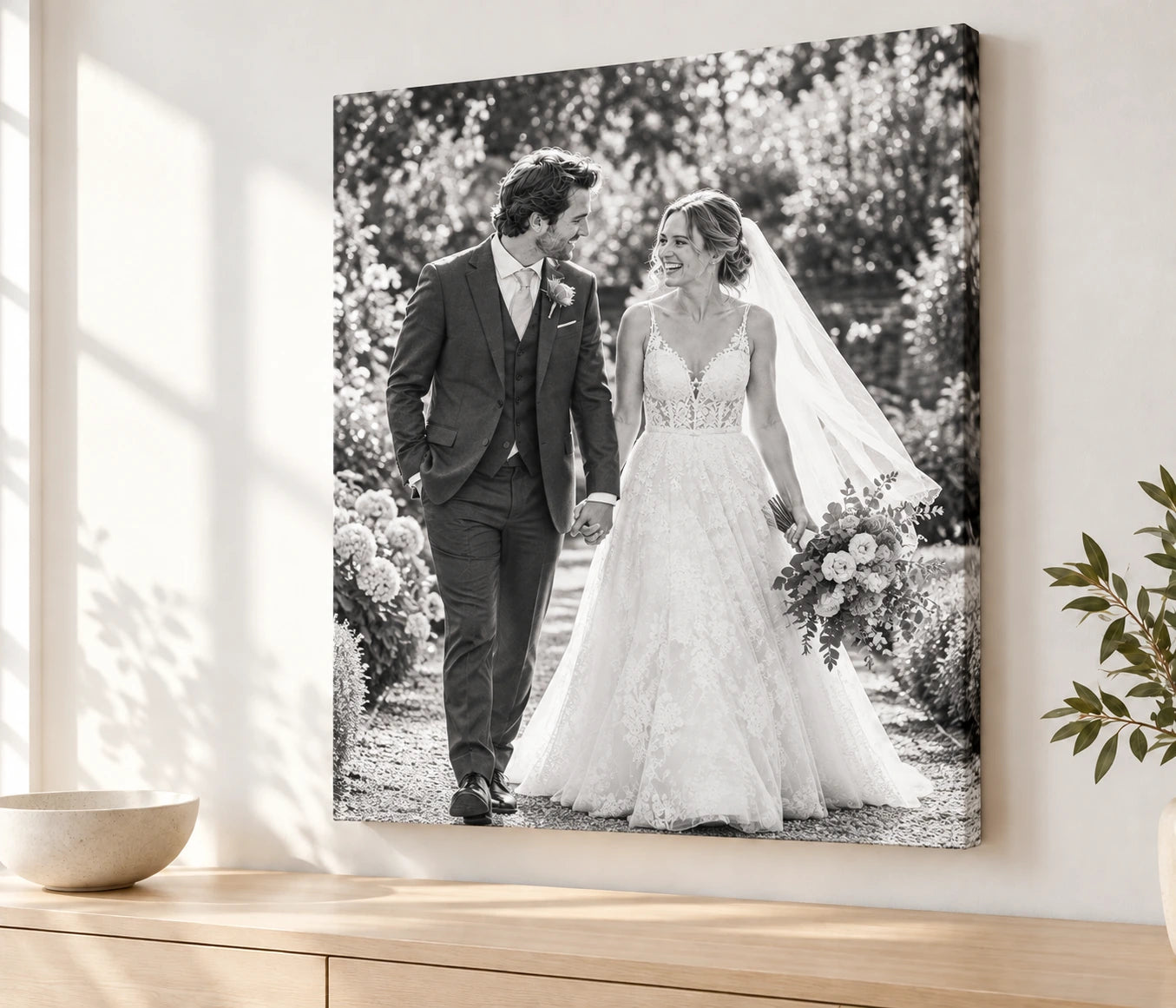 Black and white wedding photo on canvas above an oak sideboard.