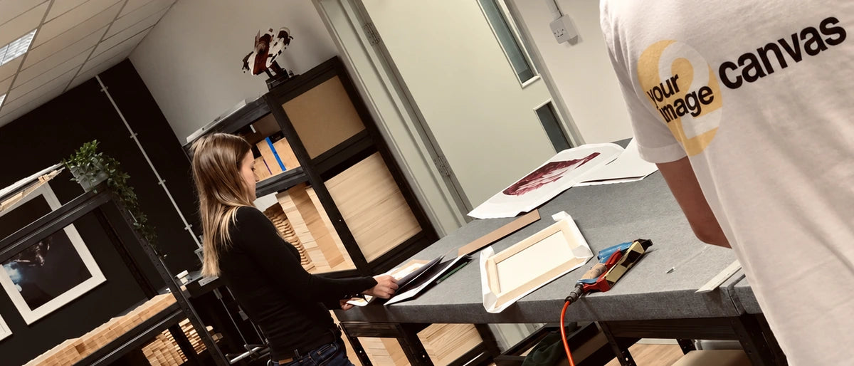 The YI2C team preparing canvas prints at the framing benches in the workshop.