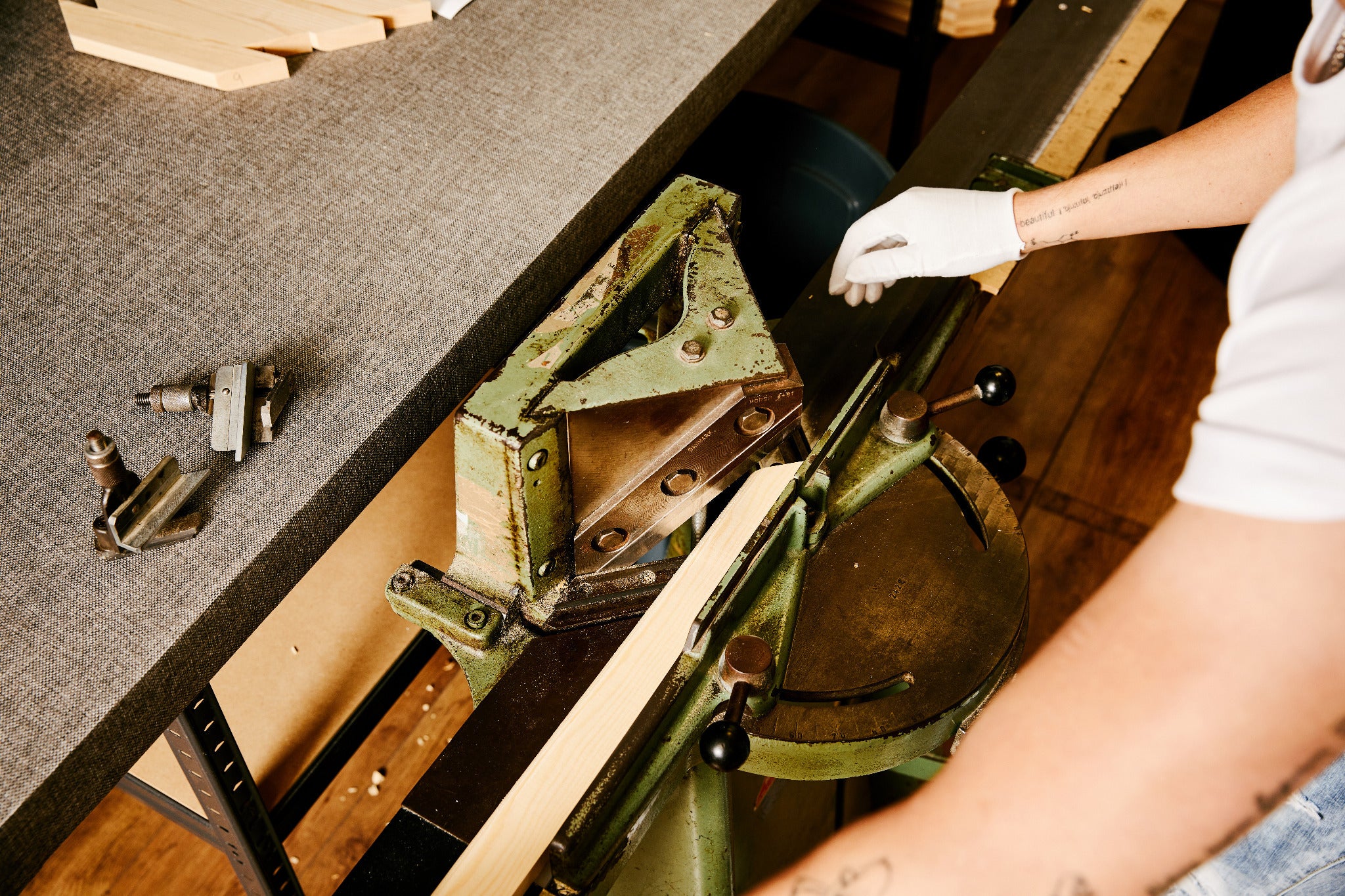 An operator cutting timber for a canvas stretcher frame in the workshop.