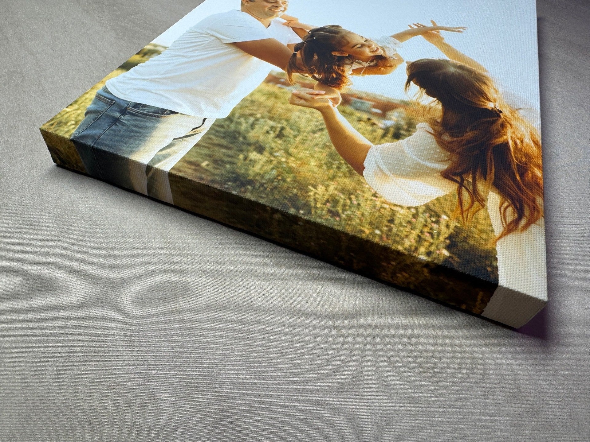Close-up of a family photo canvas print with the image continuing around the side and folded corner.