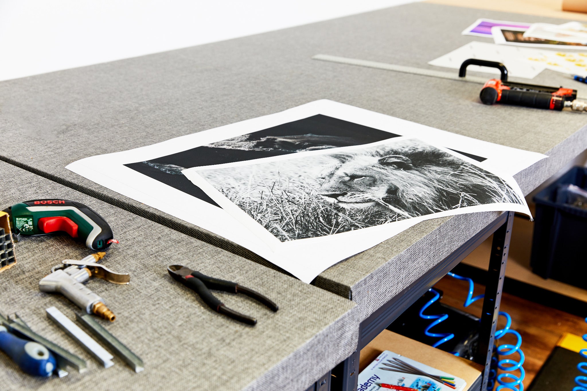 Printed canvas and tools laid out on a workshop bench.