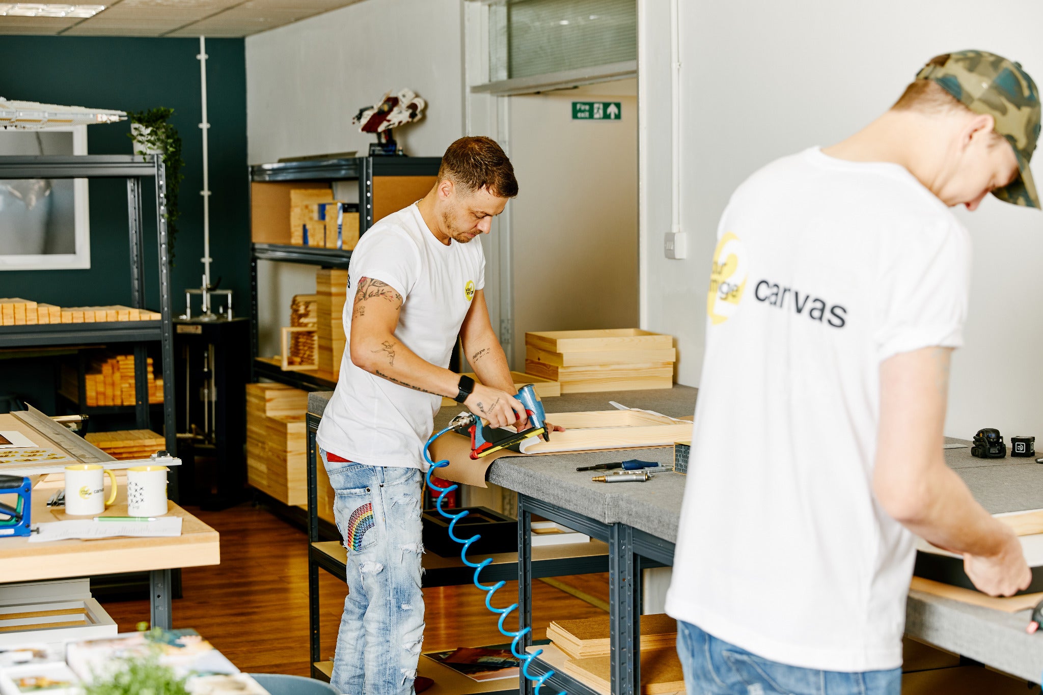 Two members of the YI2C team making prints at benches in the West Yorkshire workshop.