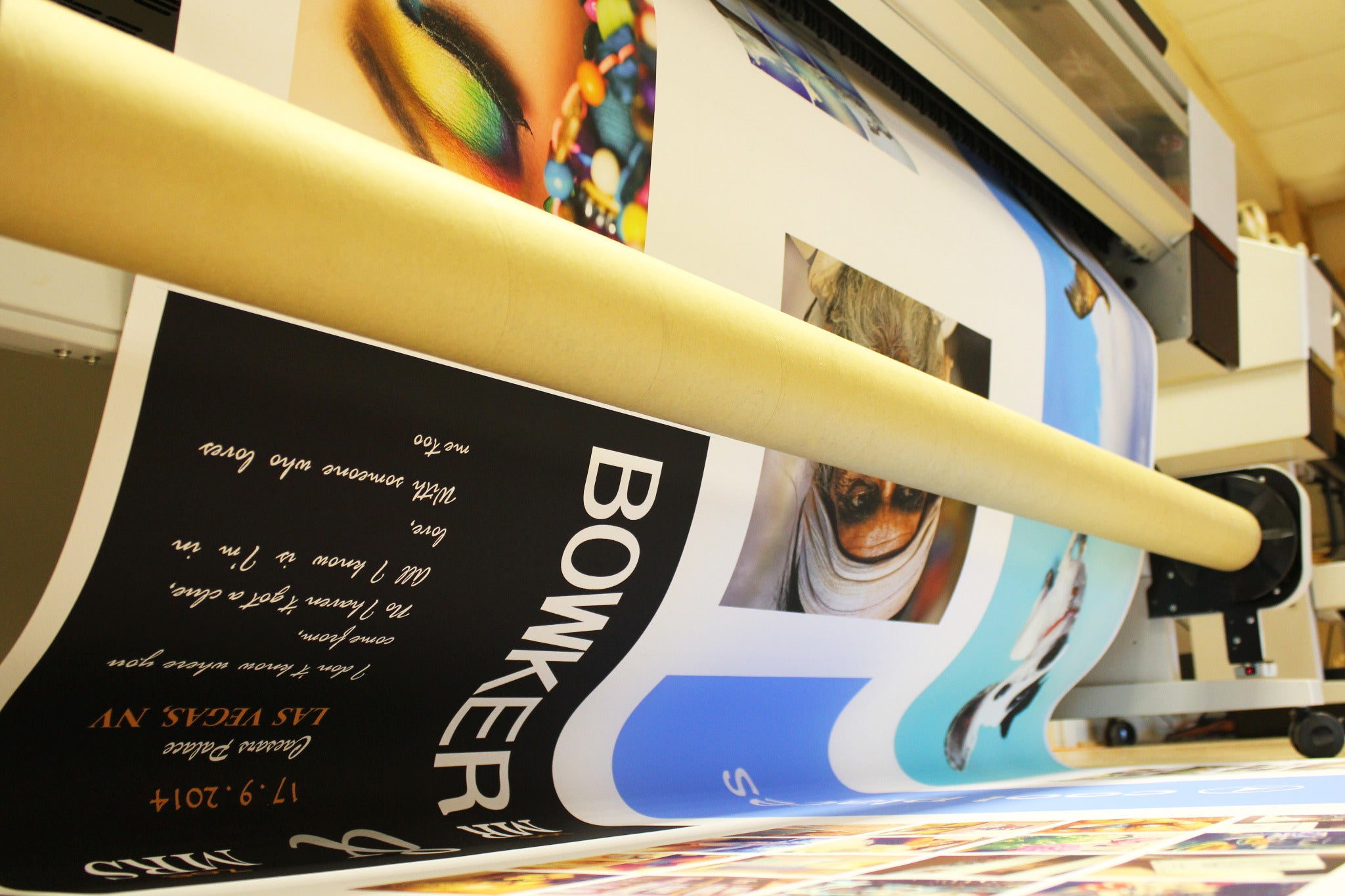 Close-up of colourful prints moving through an Epson large-format printer.