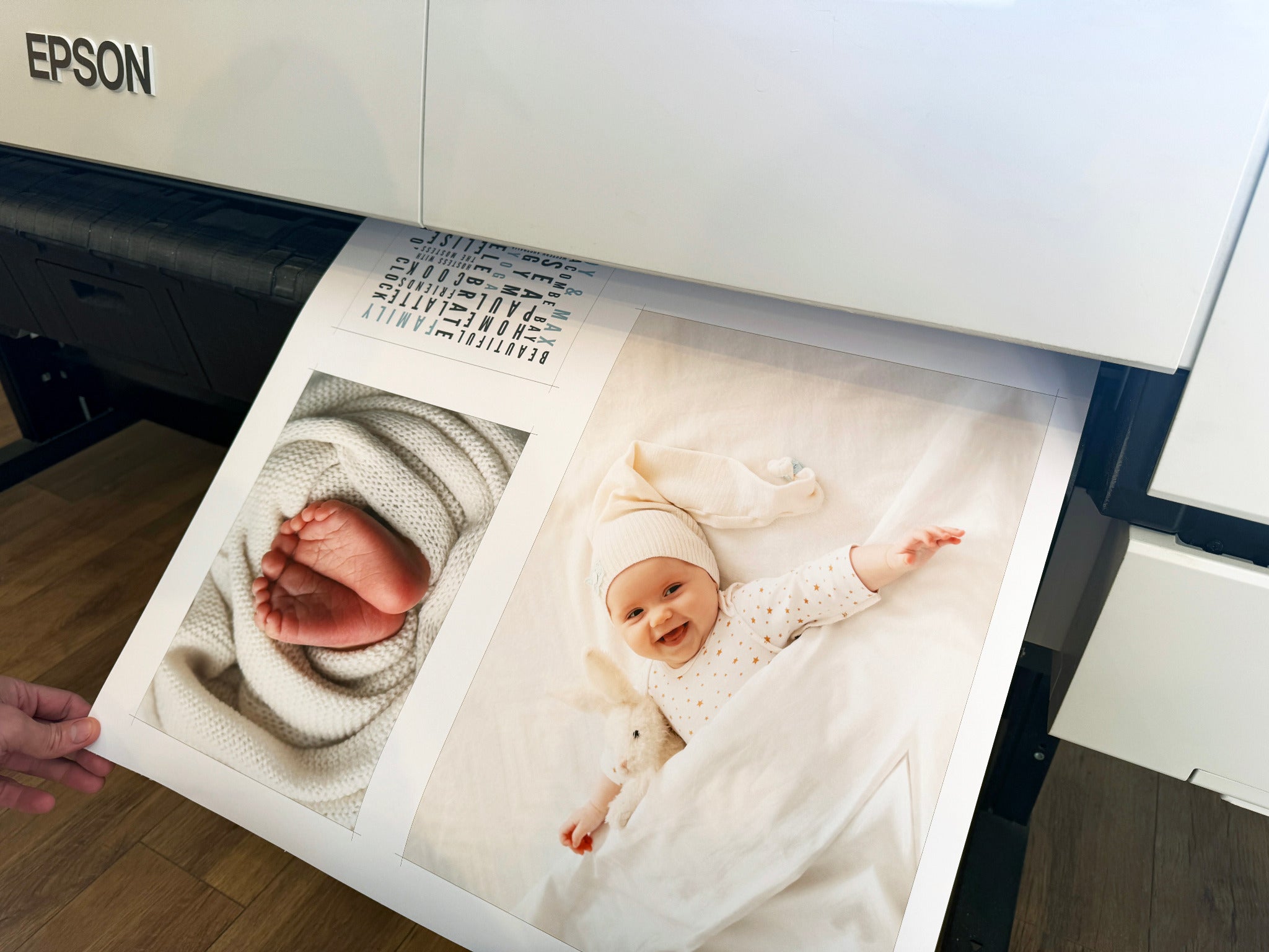 Newborn photographs being printed by an Epson large-format printer.