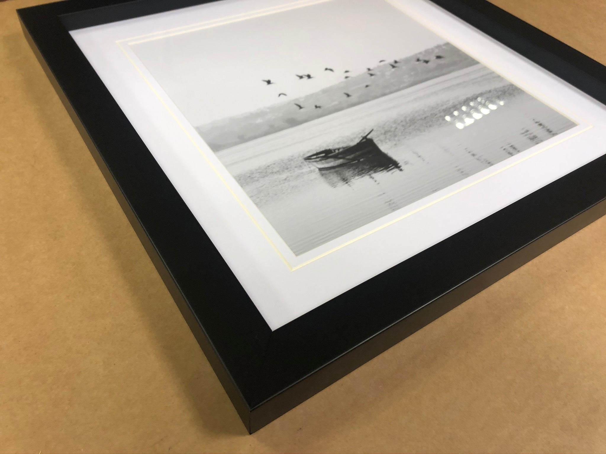 A black framed monochrome photograph with a white mount and a fine line around the opening