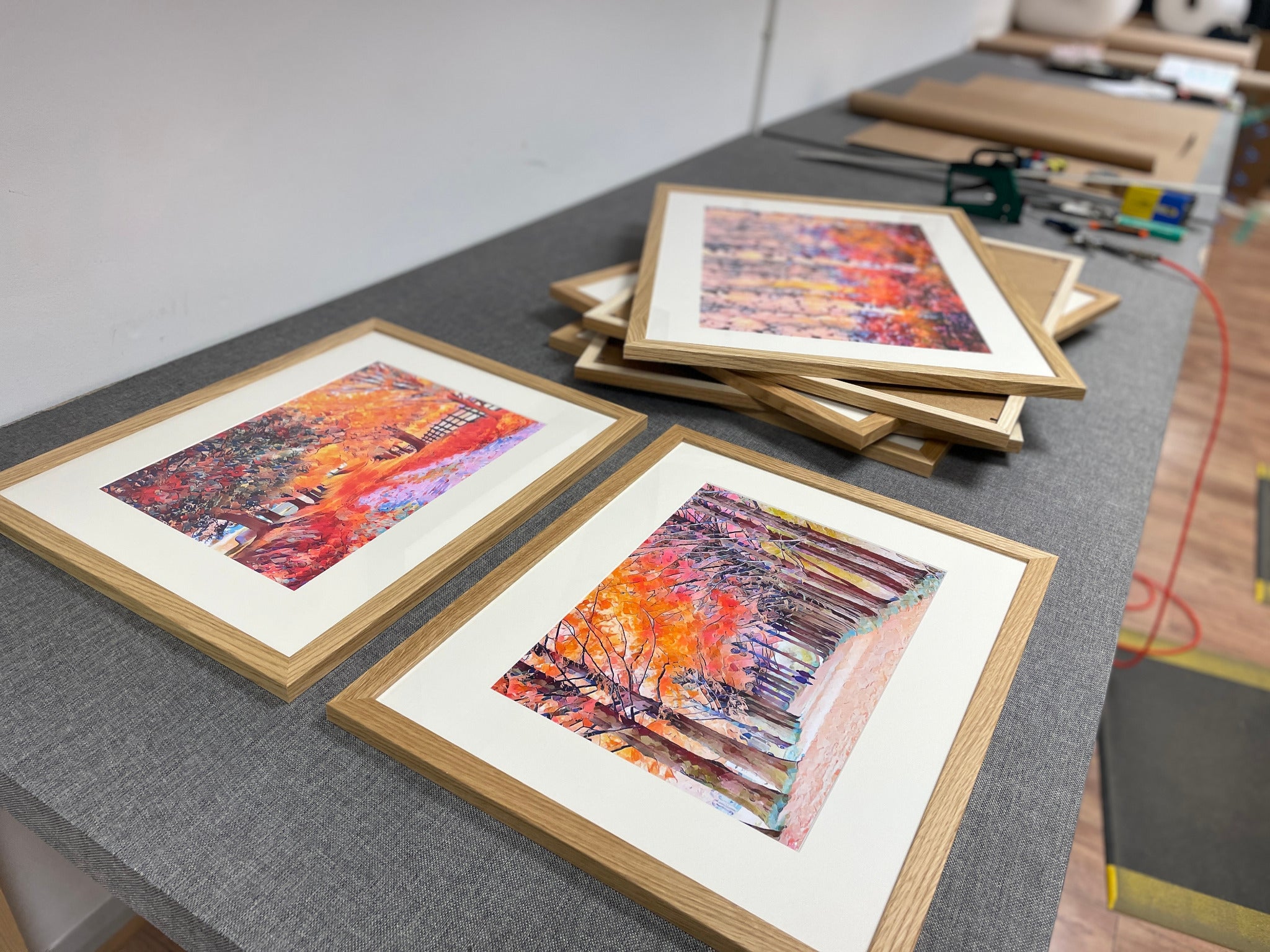 Oak-finish framed artwork laid out on the workshop bench