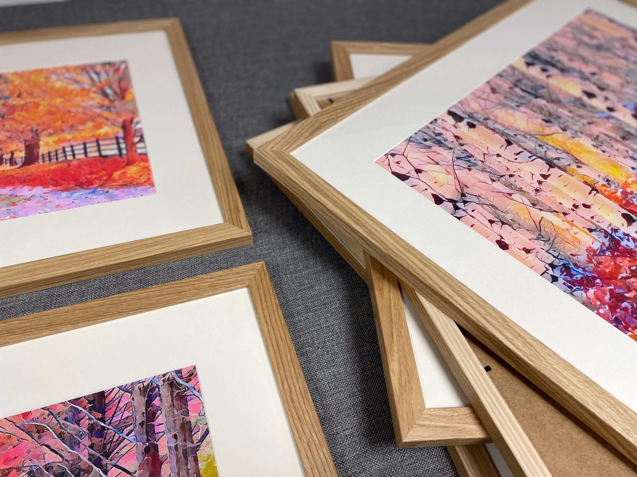 Close detail of oak-finish frames, white mounts and colourful artwork
