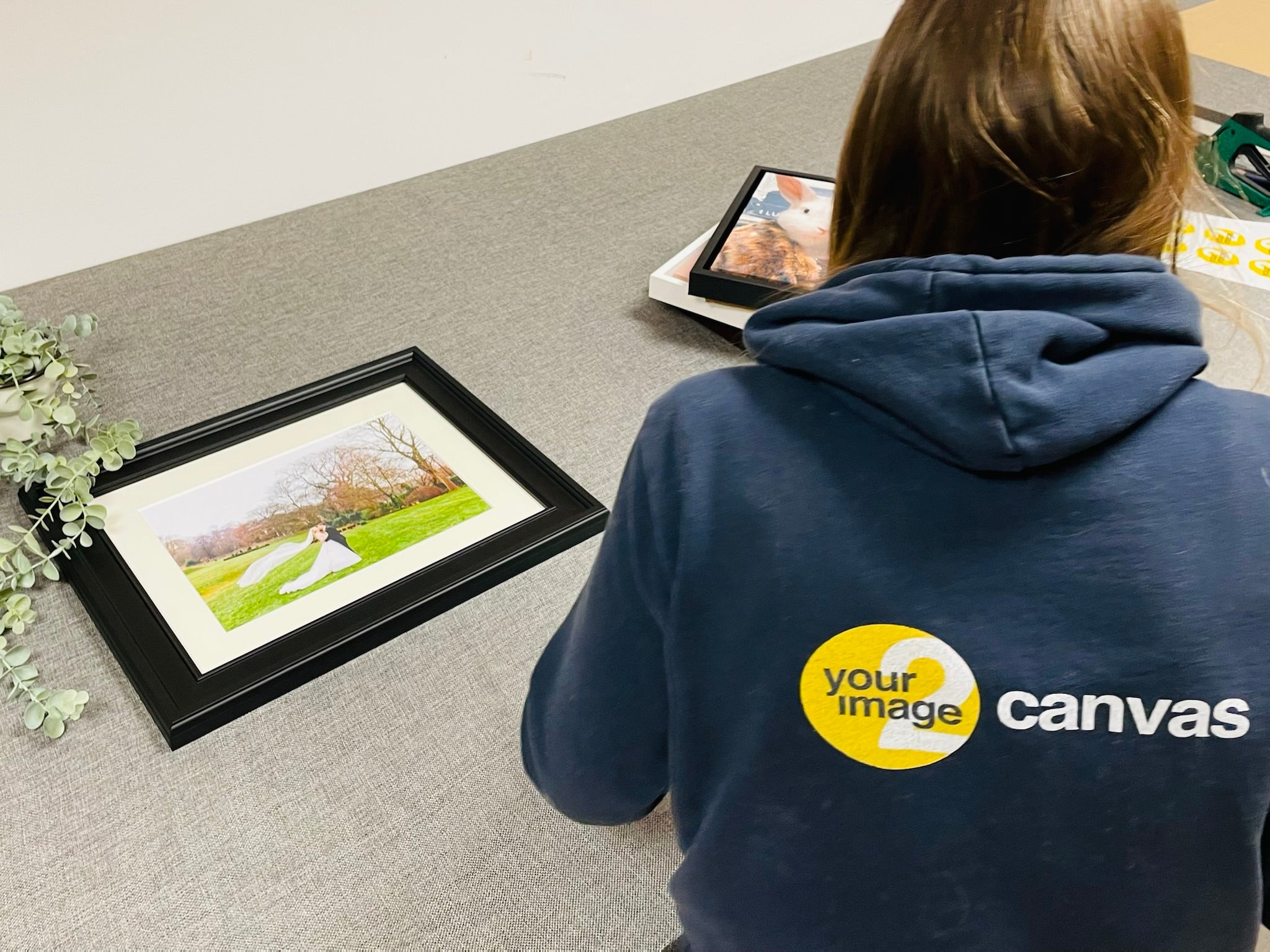 A YI2C team member alongside a framed wedding photograph at the workshop bench