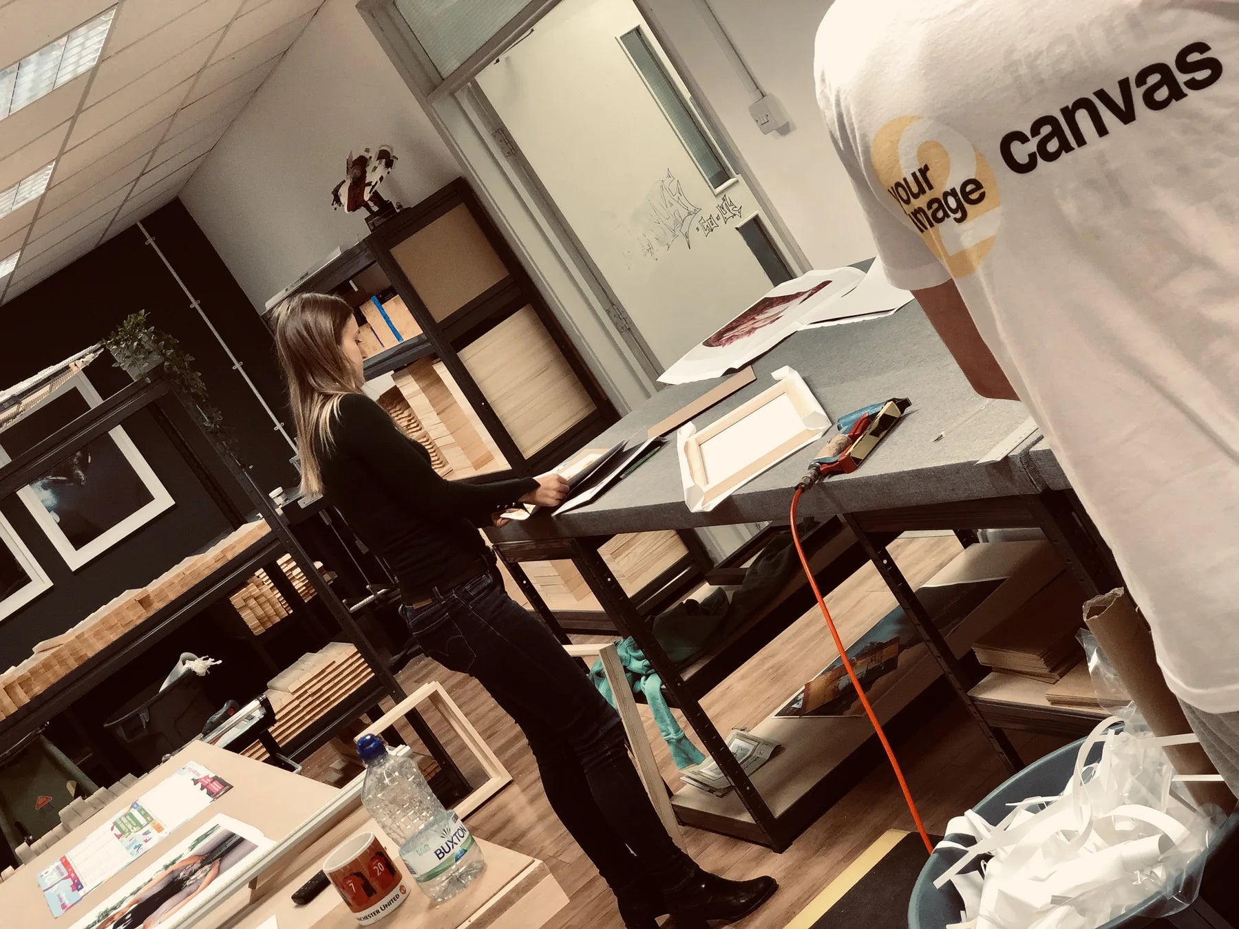 An older YI2C workshop with a team member preparing a canvas at the bench