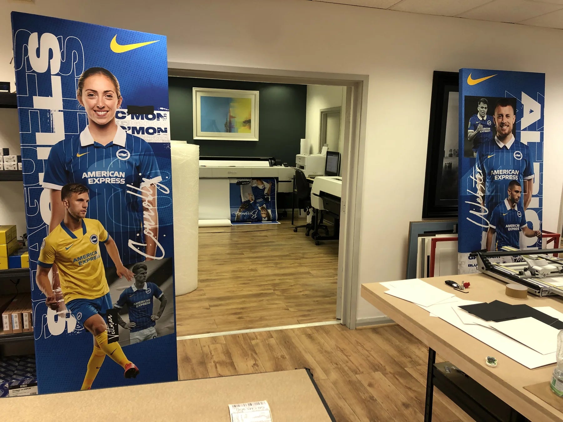 Printed life-size sports display panels arranged in the workshop