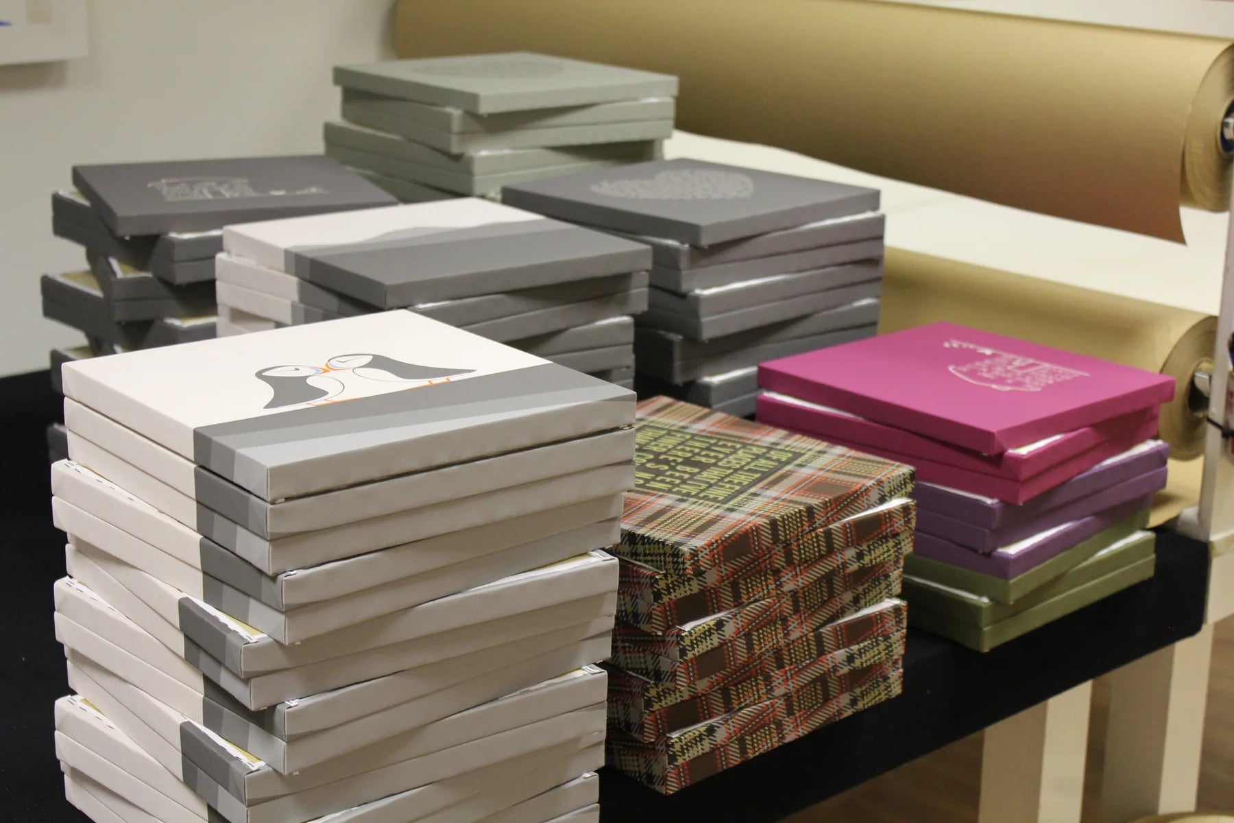 Neat batches of small finished canvases stacked across a workshop table