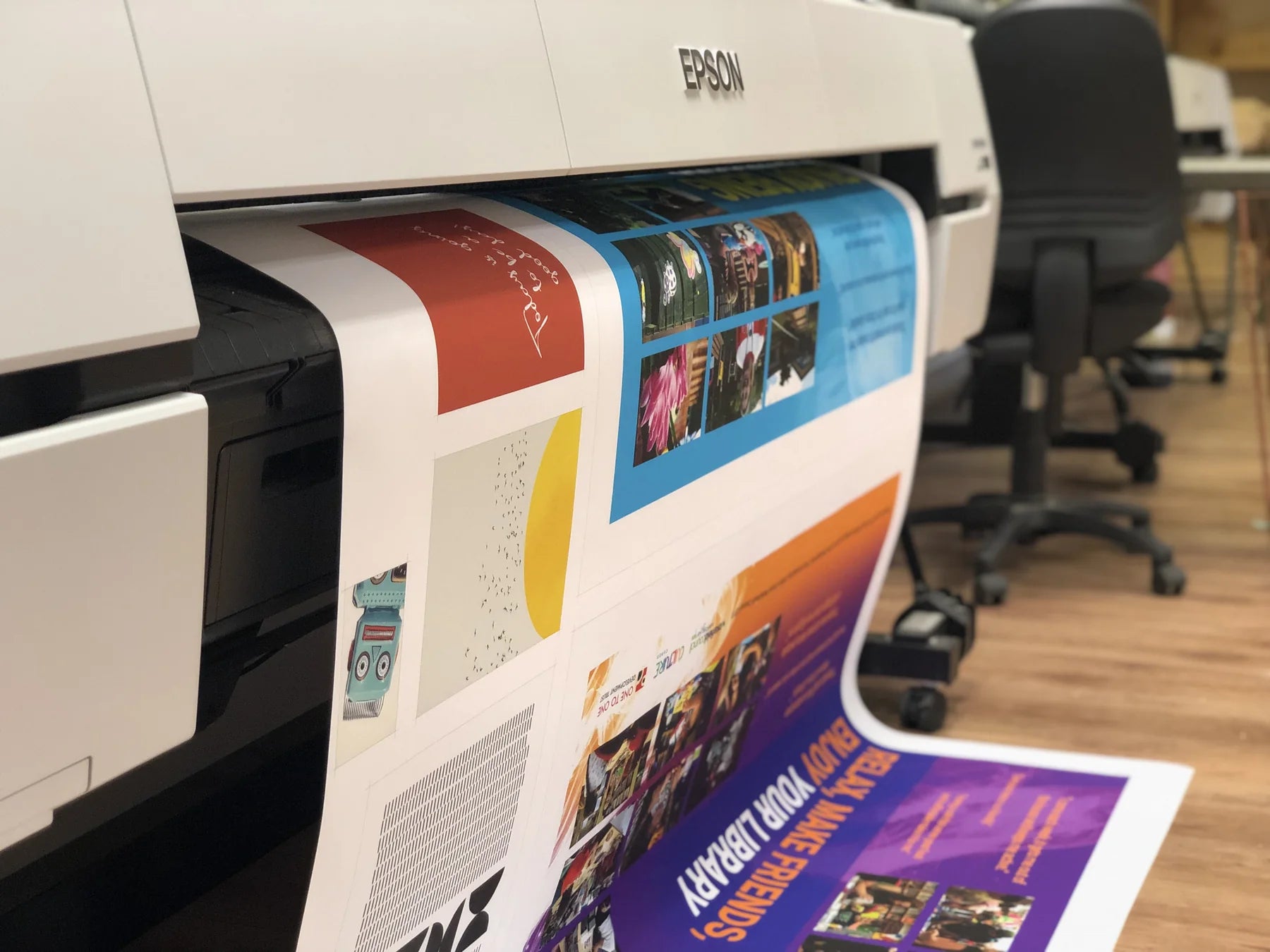 Large-format printer producing colourful artwork in the workshop