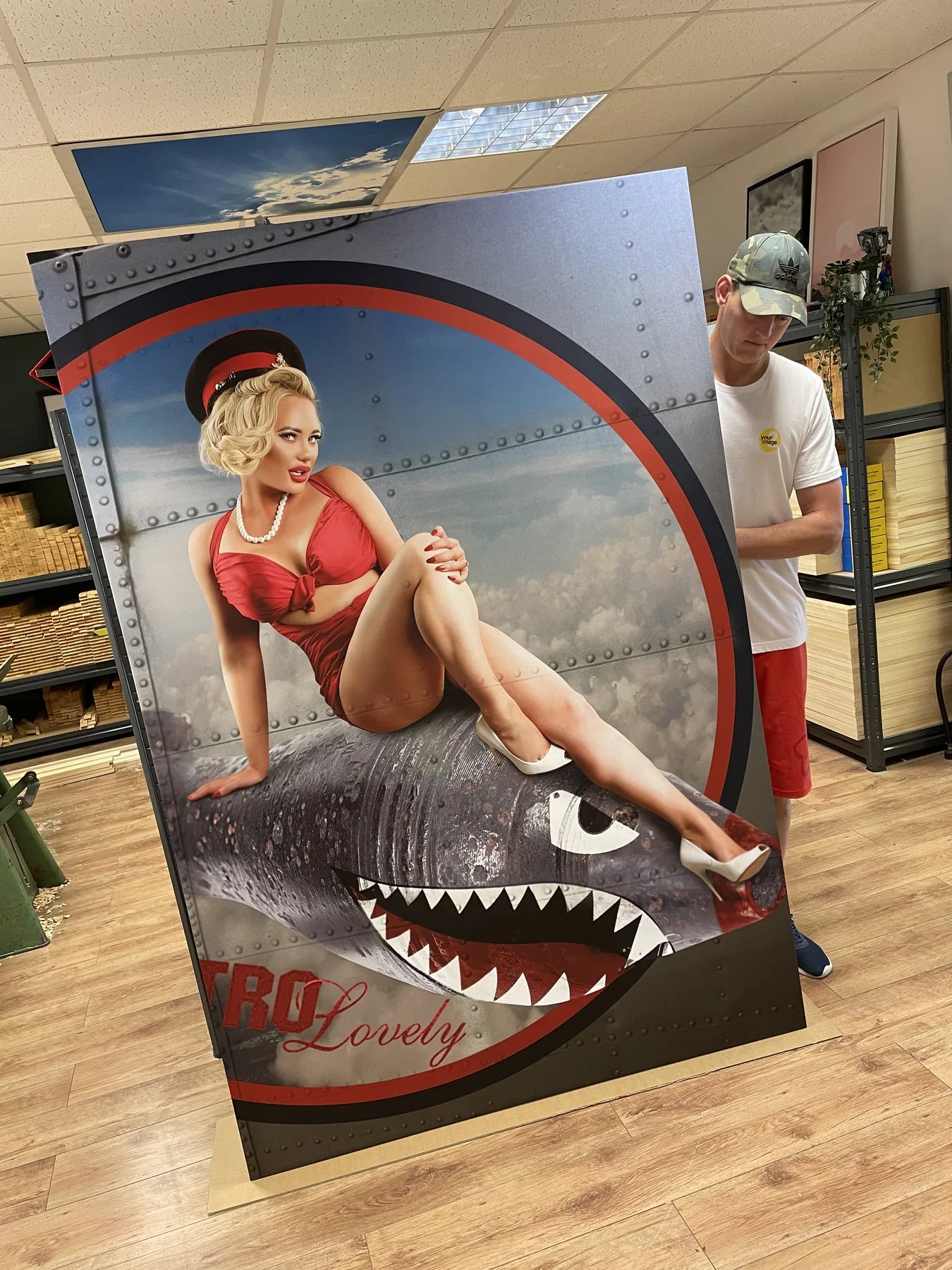 Two team members positioning a tall shaped vintage aircraft print