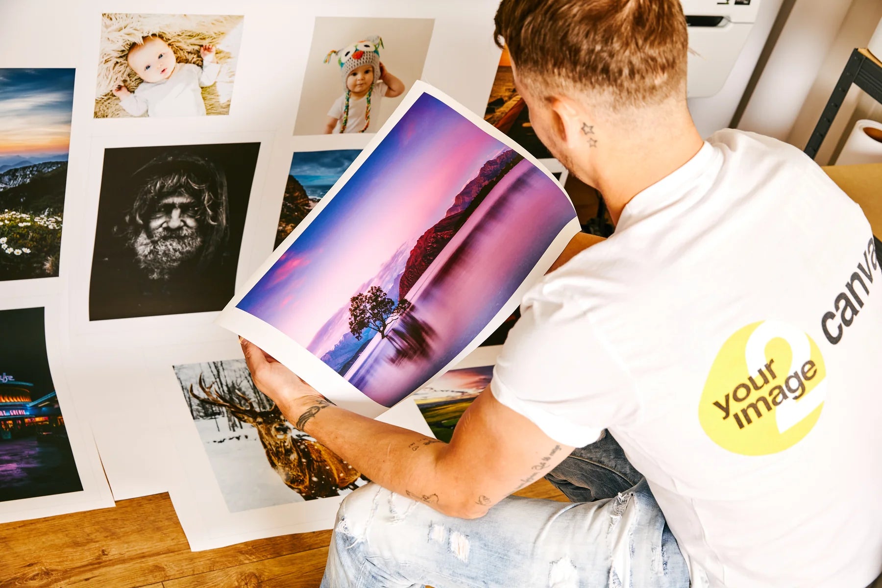 Jamie inspecting a freshly printed colour photograph in the print room