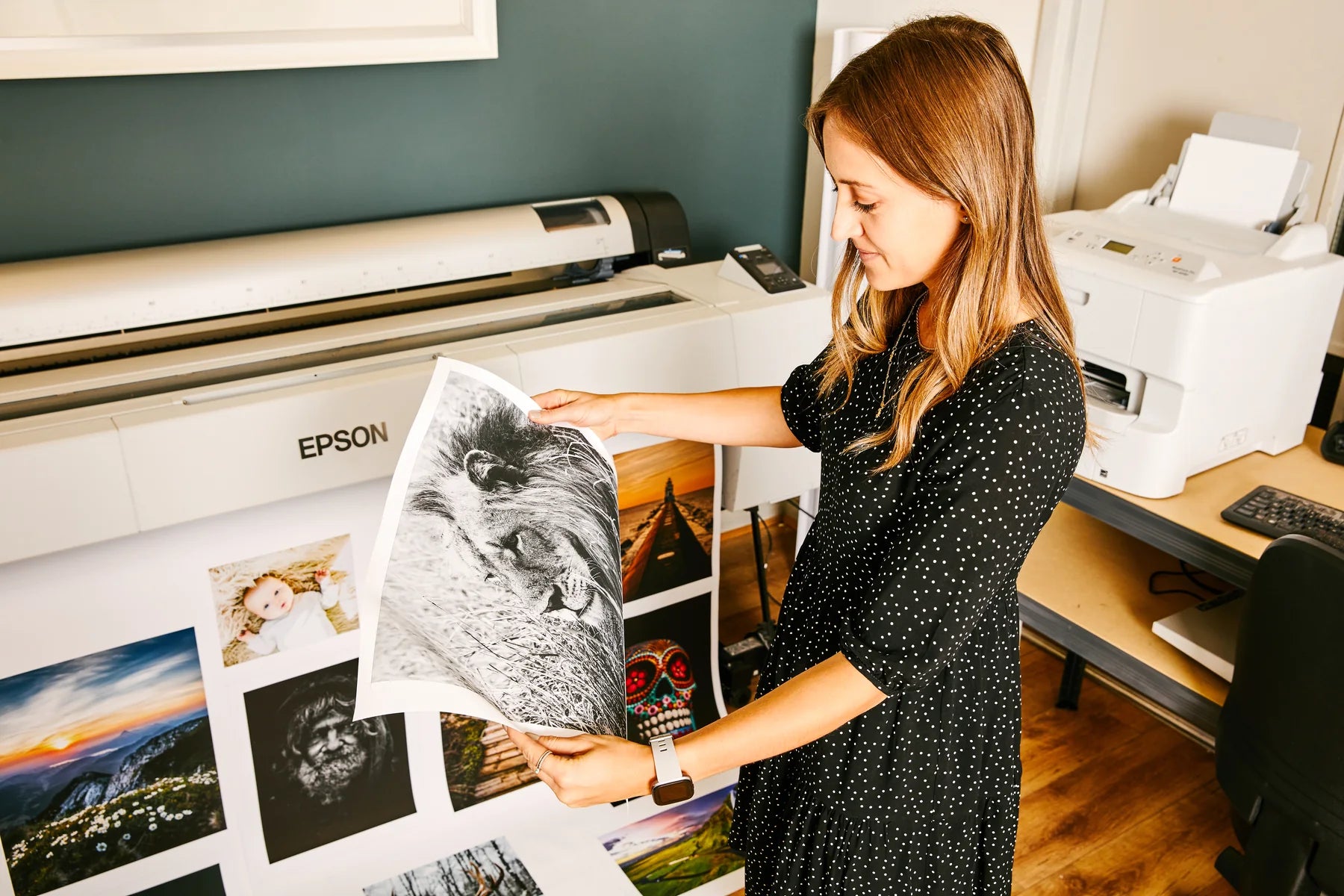 A team member checking a monochrome photographic print beside an Epson printer