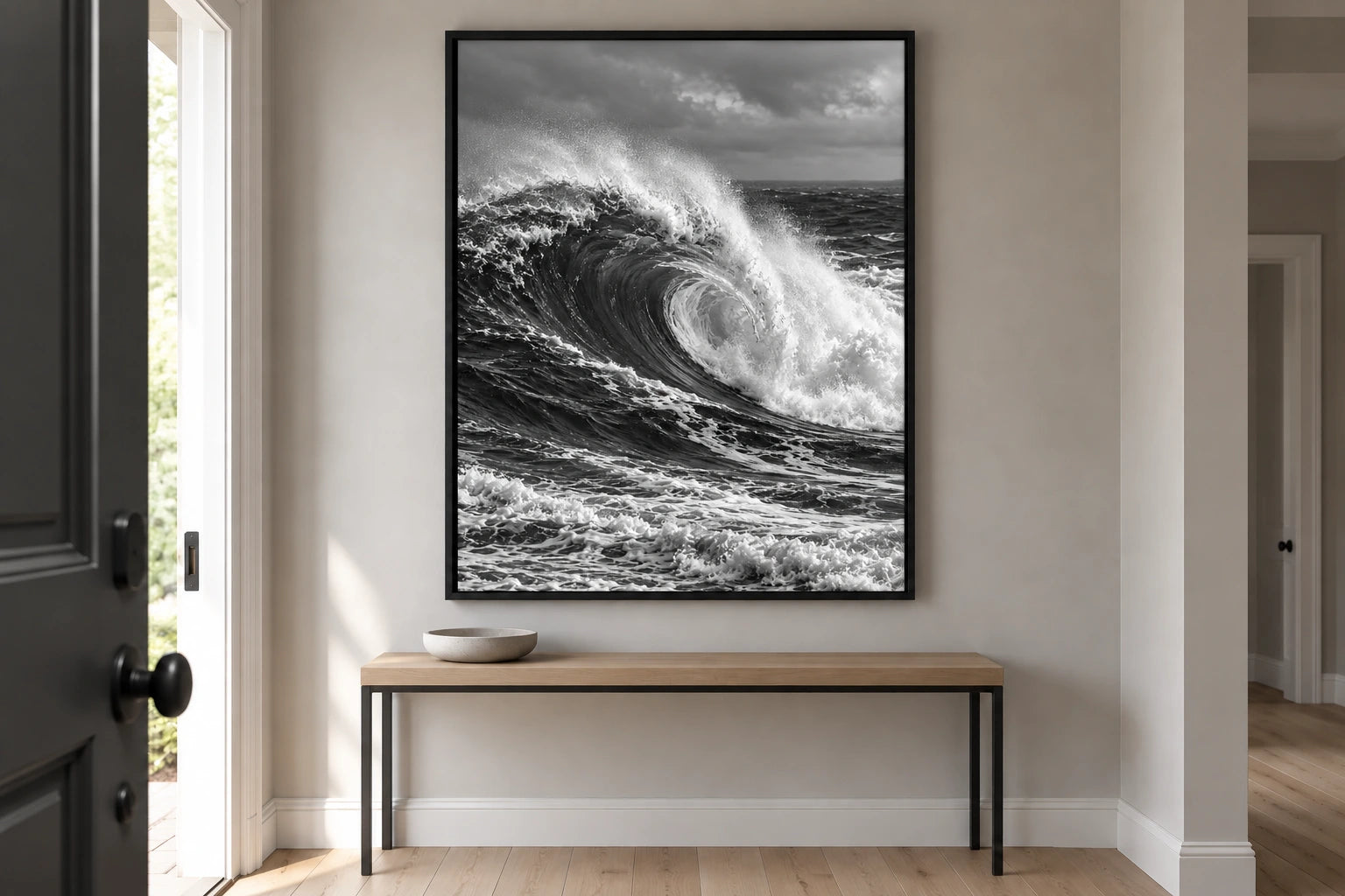 The same pale hallway, console and black floating frame, now displaying the bright breaking-wave composition.