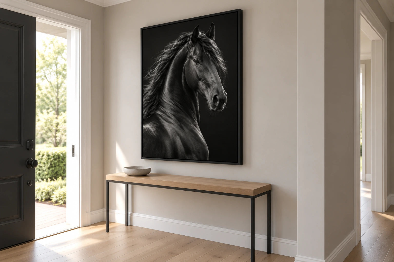 Dark horse canvas in a black floating frame above a console in a pale entrance hallway.