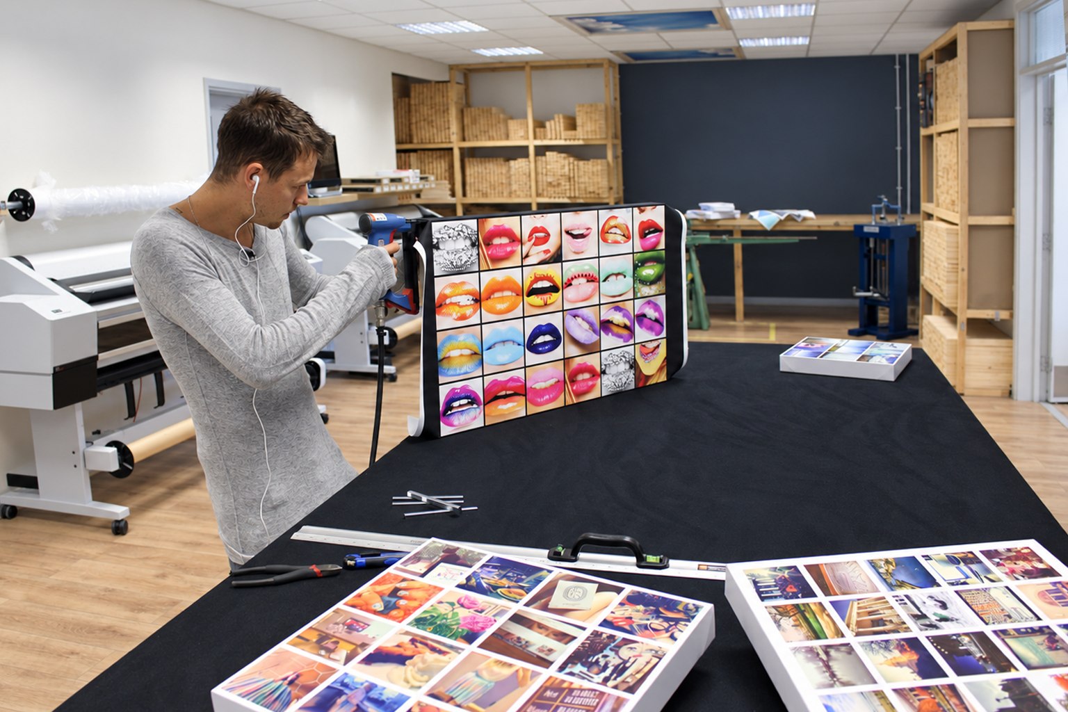 A YI2C maker finishing a colourful multi-photo collage canvas in the workshop