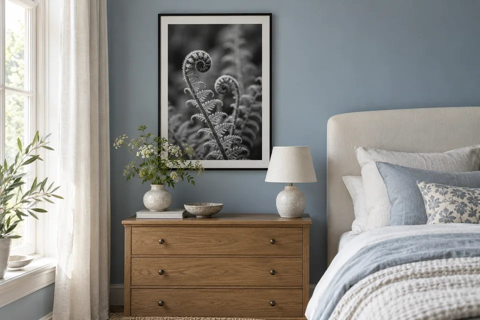 A framed black-and-white botanical photograph displayed in a blue bedroom.