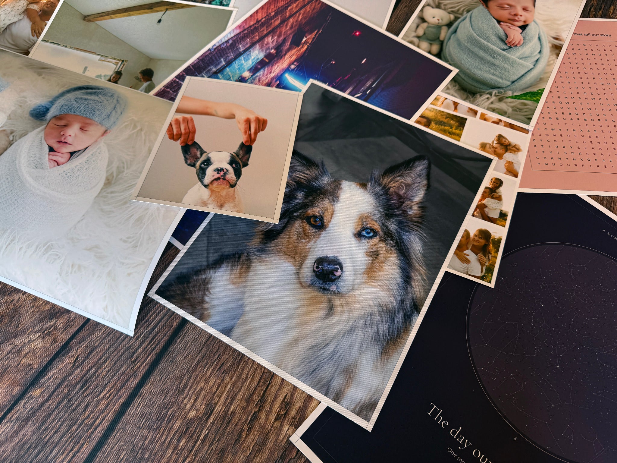 Photo poster prints featuring a newborn, dogs and colourful artwork on a wooden table.