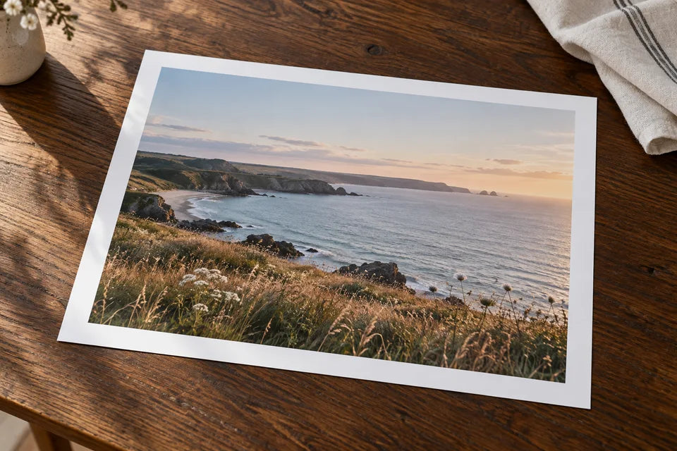 A landscape photograph printed with a broad white paper border on a dark oak table.