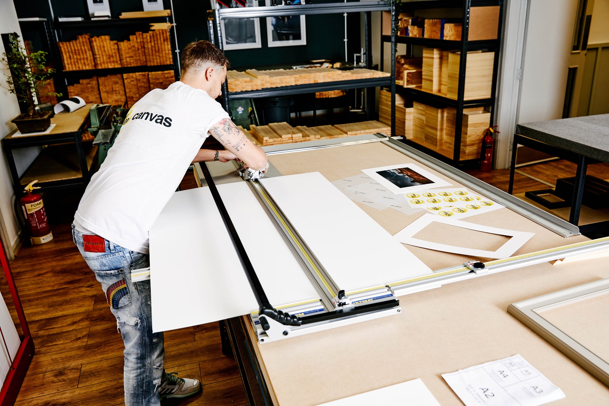 A team member using a large mount cutter at a workshop bench.