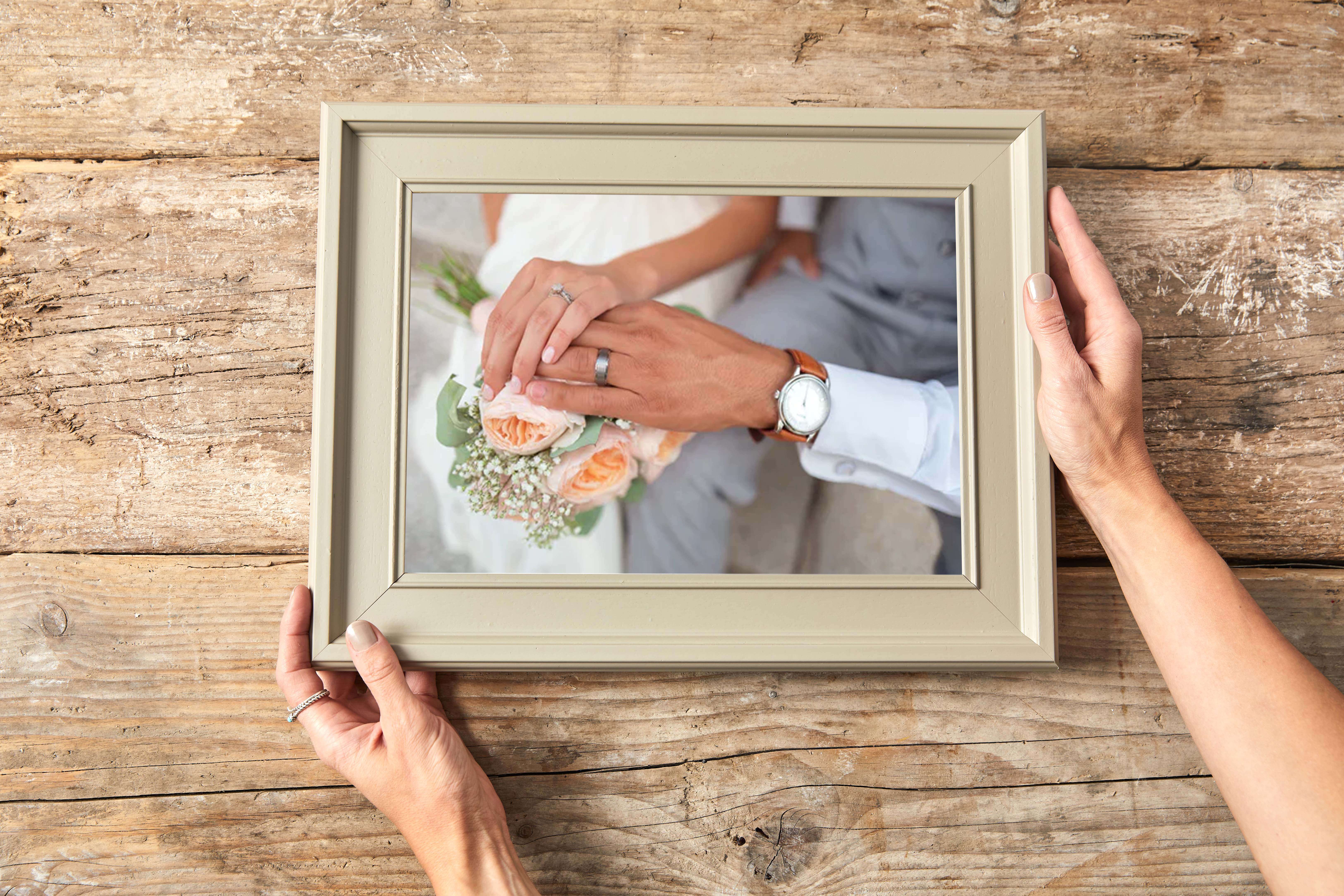 photograph of bride and grroms hands and rings on their wedding day printed onto cheap quality canvas and displayed in a hand made custom frame to display in home