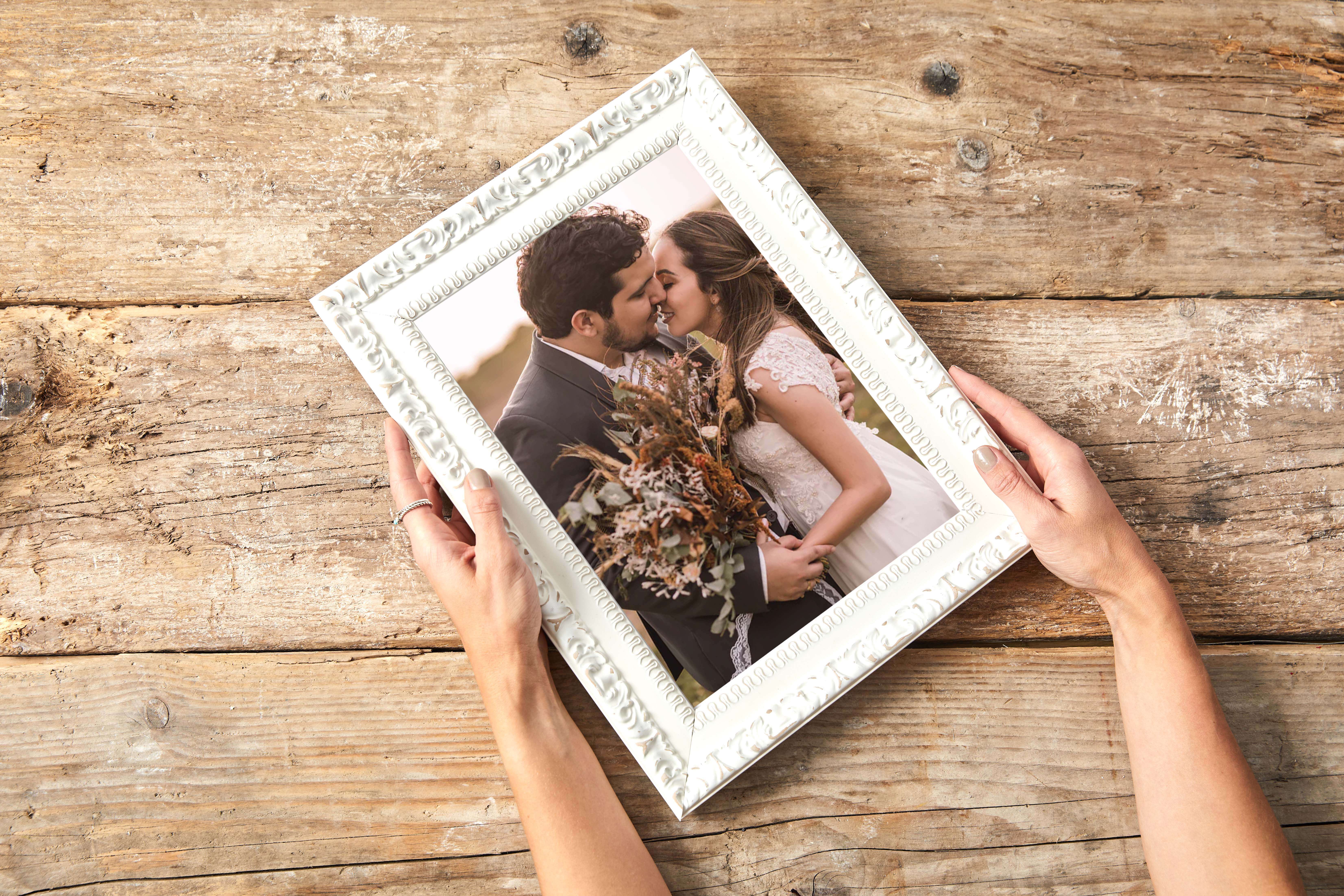 beautiful shot of bride and groom kissing on their wedding dayprinted onto best canvas uk and displayed in a beautiful white picture frame 