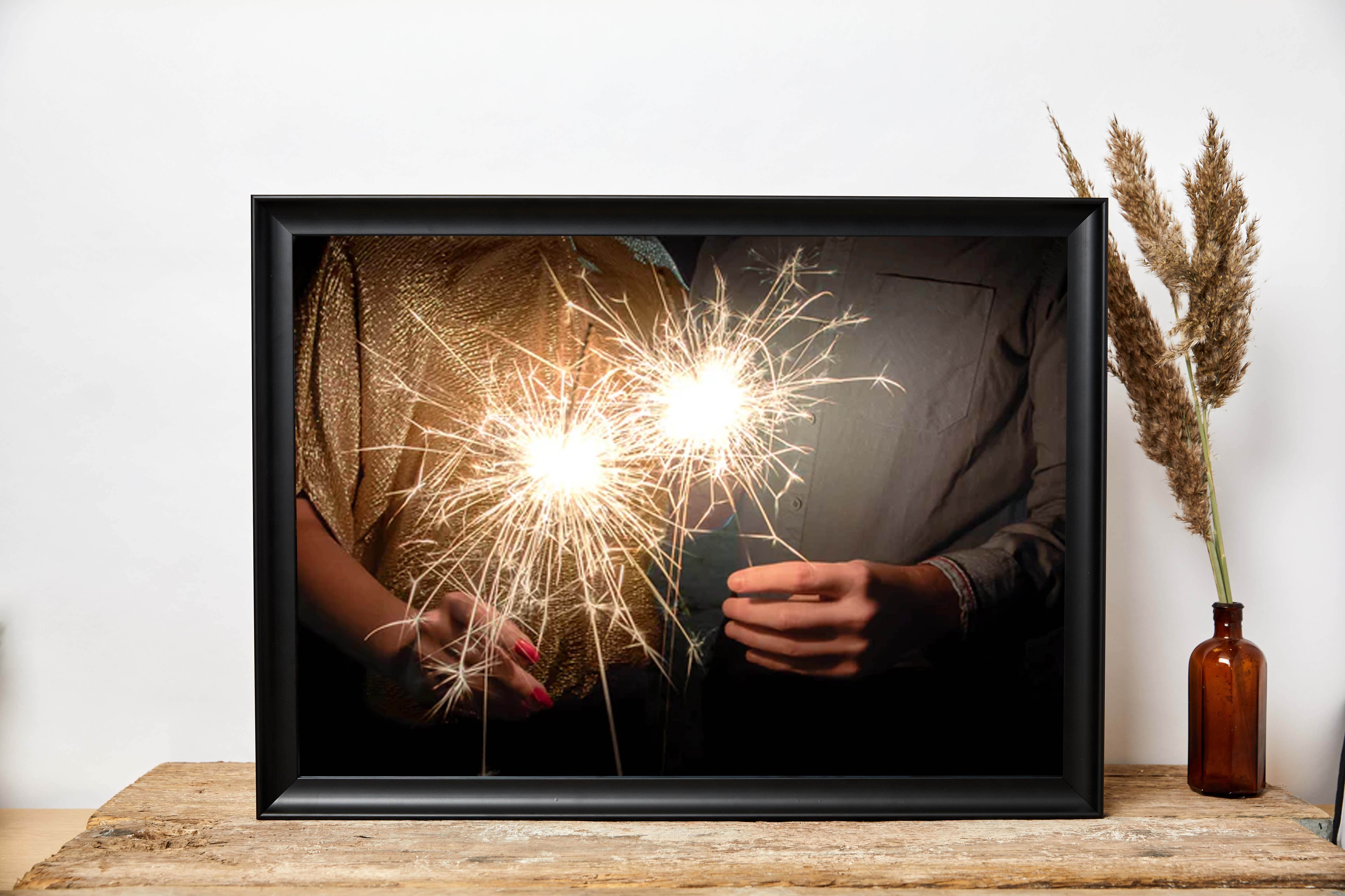 photograph of couple holding celebration sparklers on bonfire night displayed in a classic cheap black canvas frame with free next day delivery uk