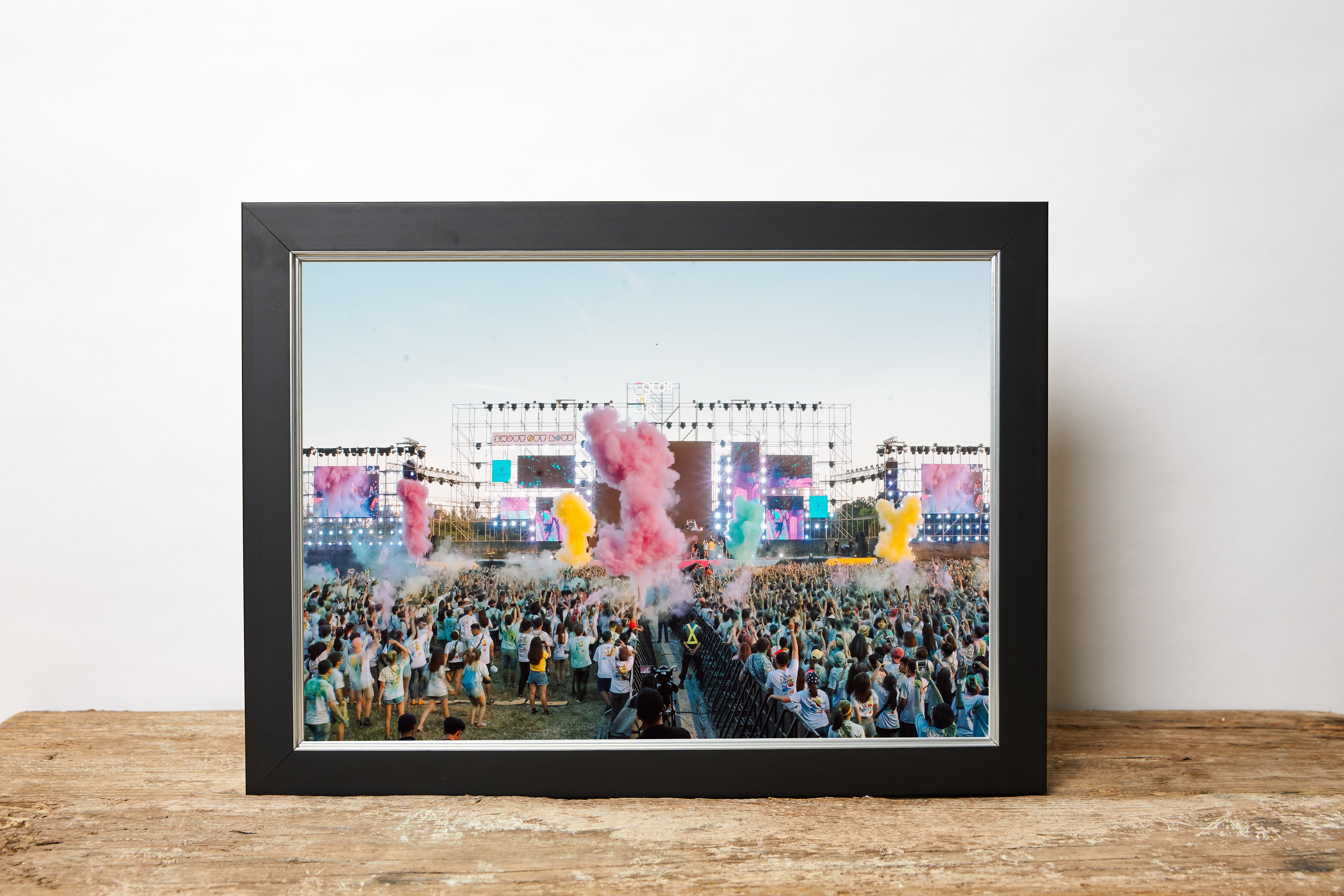 Image of festival, stage and colourful smoke displayed in a beautiful custom black picture frame made to order.