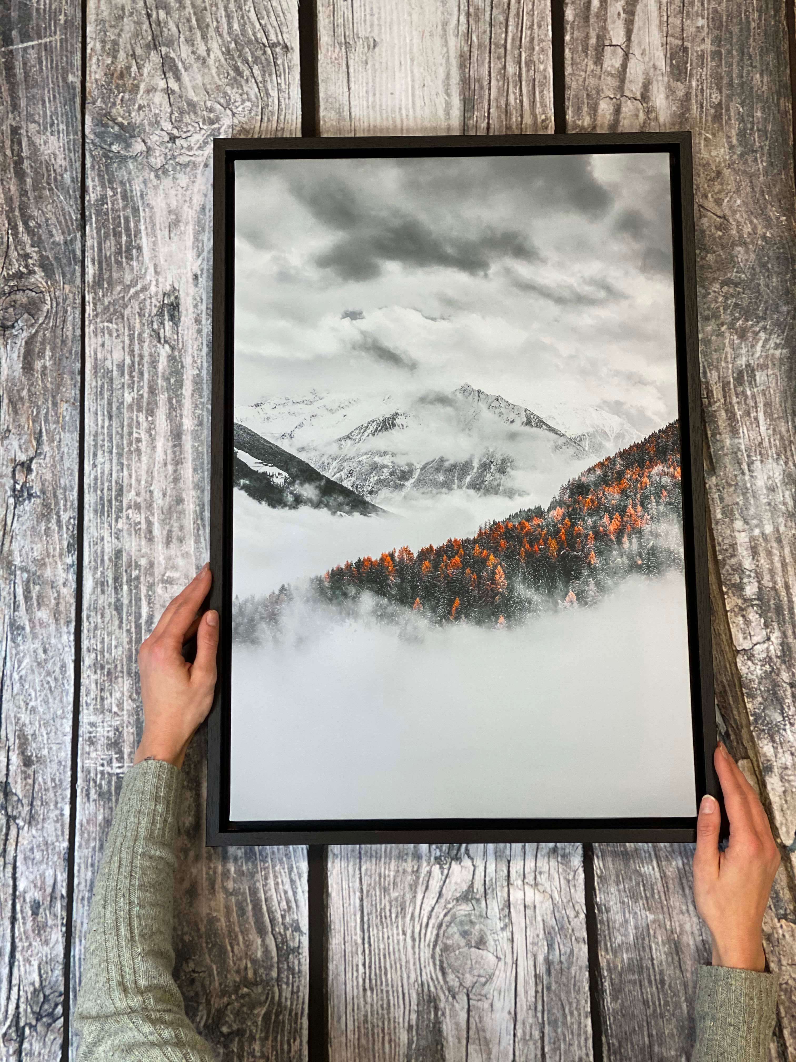 A beautiful custom canvas print of misty winter snowy mountains finished with a black made to measure frame 
